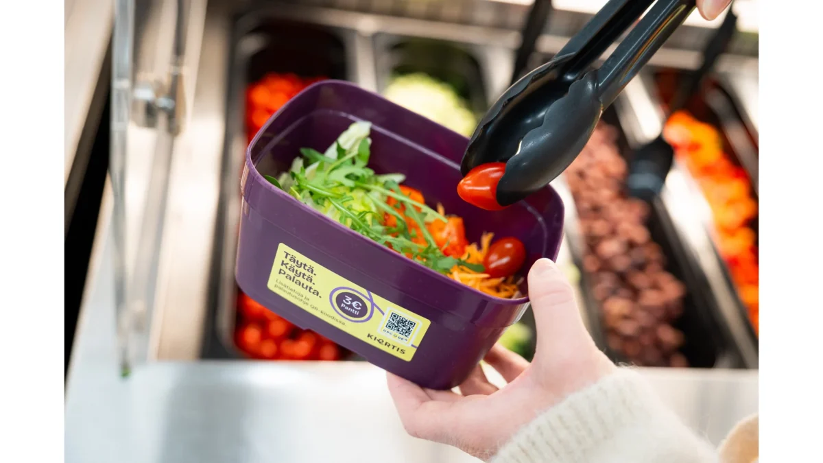 A purple Kiertis reusable food container being filled at a store salad counter.