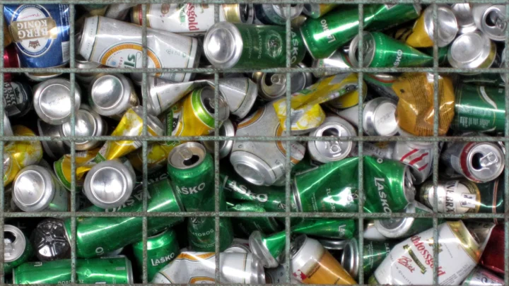 Used aluminum drinks cans collected behind a wire mesh at a recycling plant in Ptuj, Slovenia