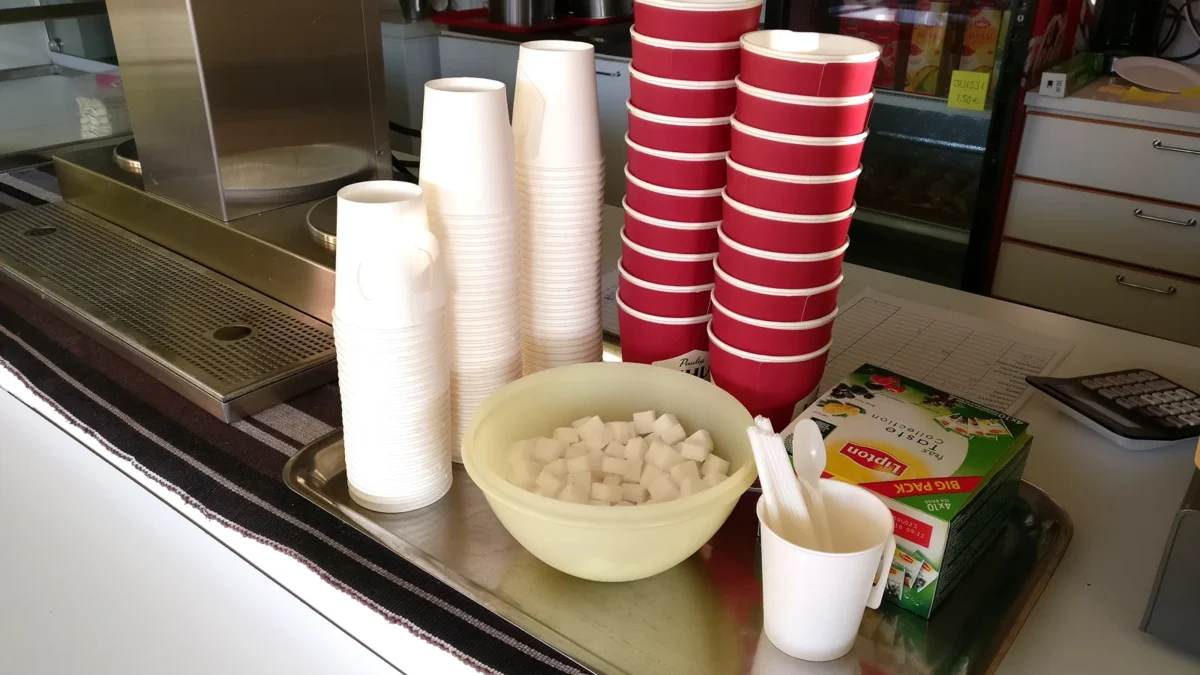 Paper coffee cups and sugar cubes arranged in a cafeteria