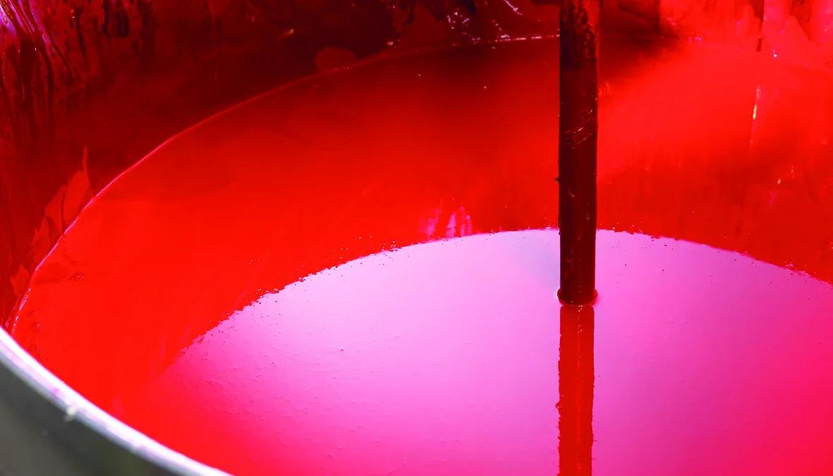 Bright red printing ink in a mixing vessel with a vertical stirring shaft
